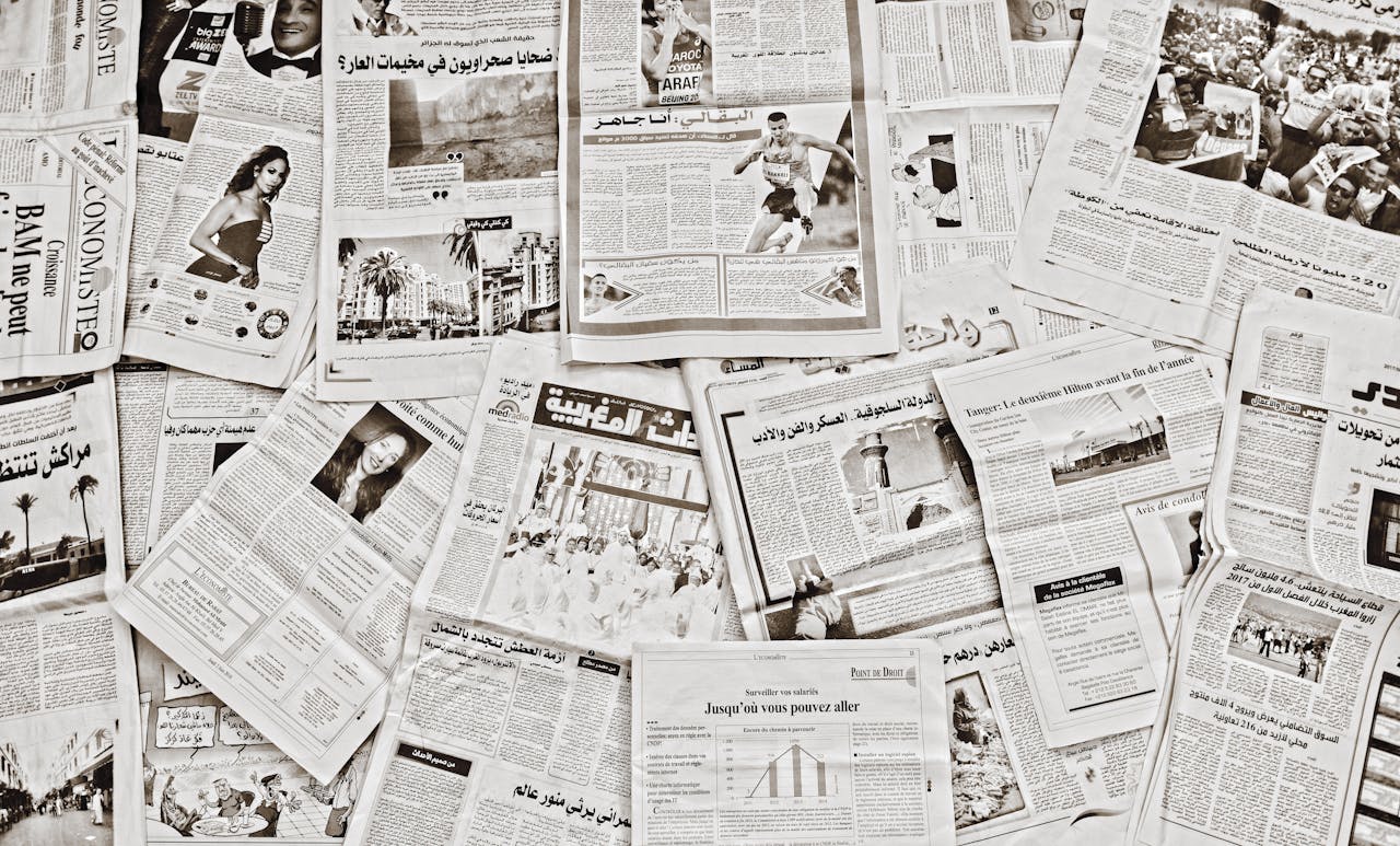services-03 A flat lay of Arabic newspapers in Fès, Morocco, showcasing diverse articles.